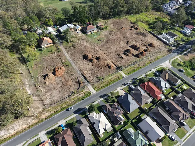 Aerial view of the cleared Albert Street site in Goodna, ready for civil works, beside an established residential street.